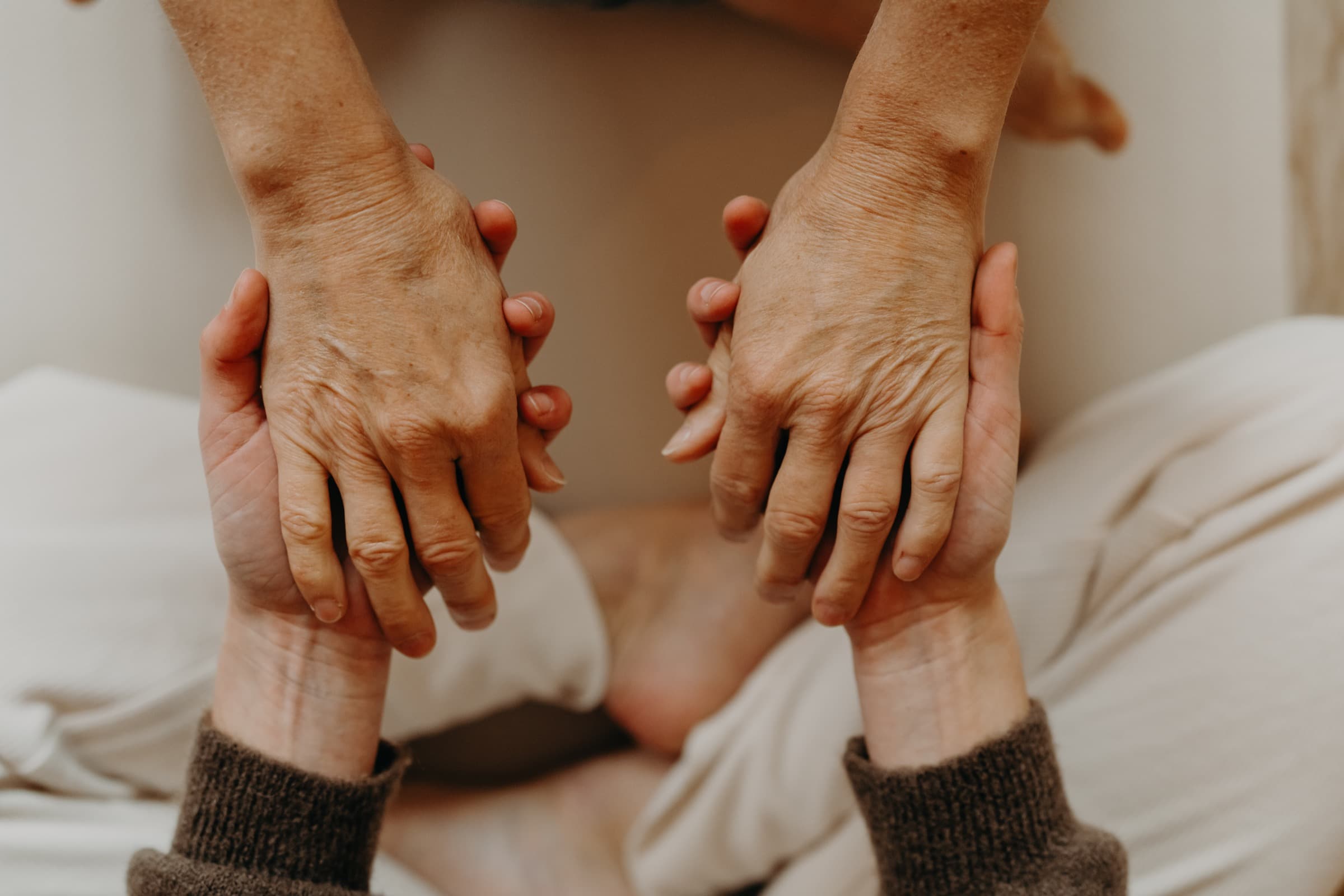 Deux mains accompagnent d'autres mains — symbole du soin et de la relation thérapeutique